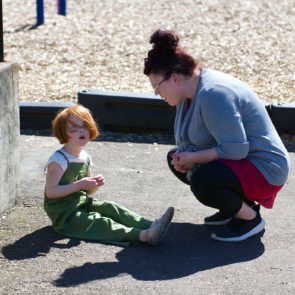 Teacher helping a student on the playground